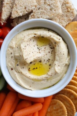 Hummus in a bowl with dipping options around it