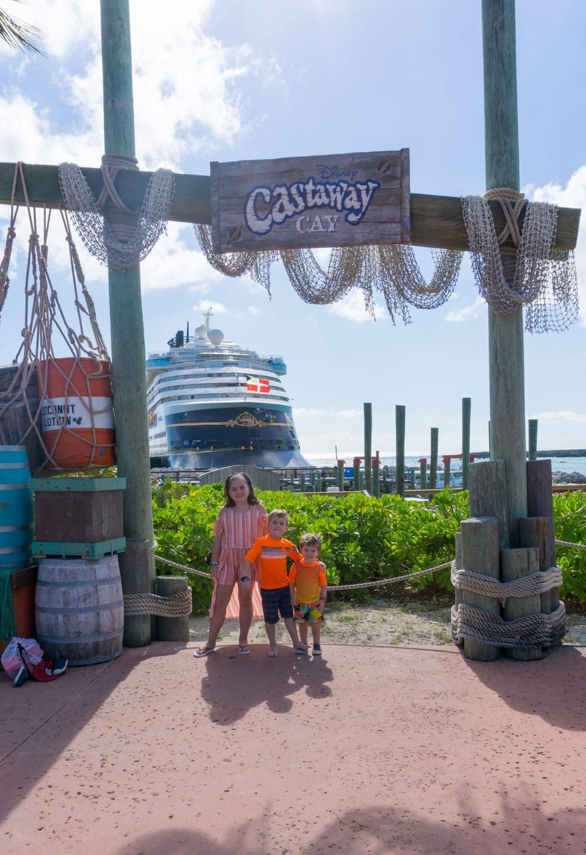 The kids with the Disney cruise ship behind them