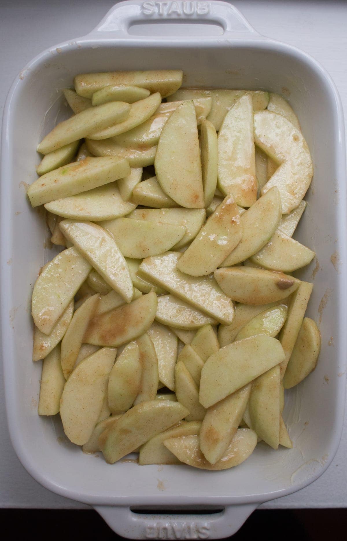 sliced apples in dish with other ingredients on top