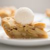 A slice of apple pie with vanilla ice cream on top