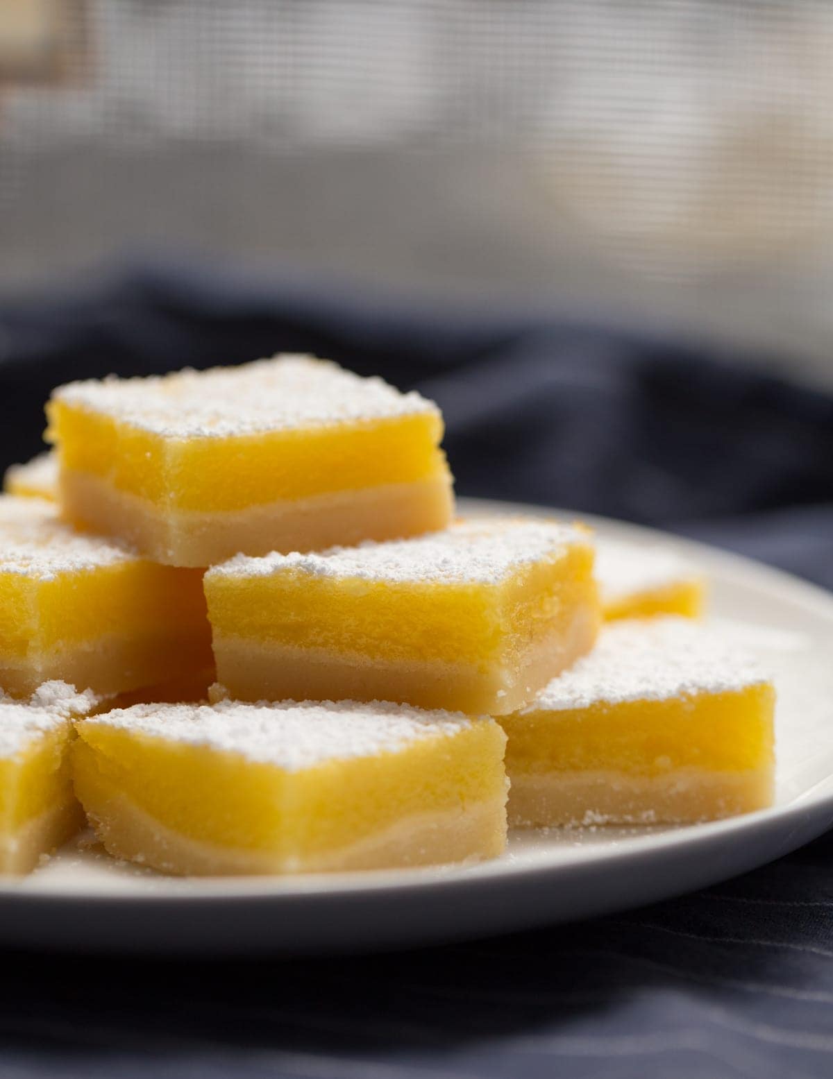 lemon bars stacked on top of each other on a white plate