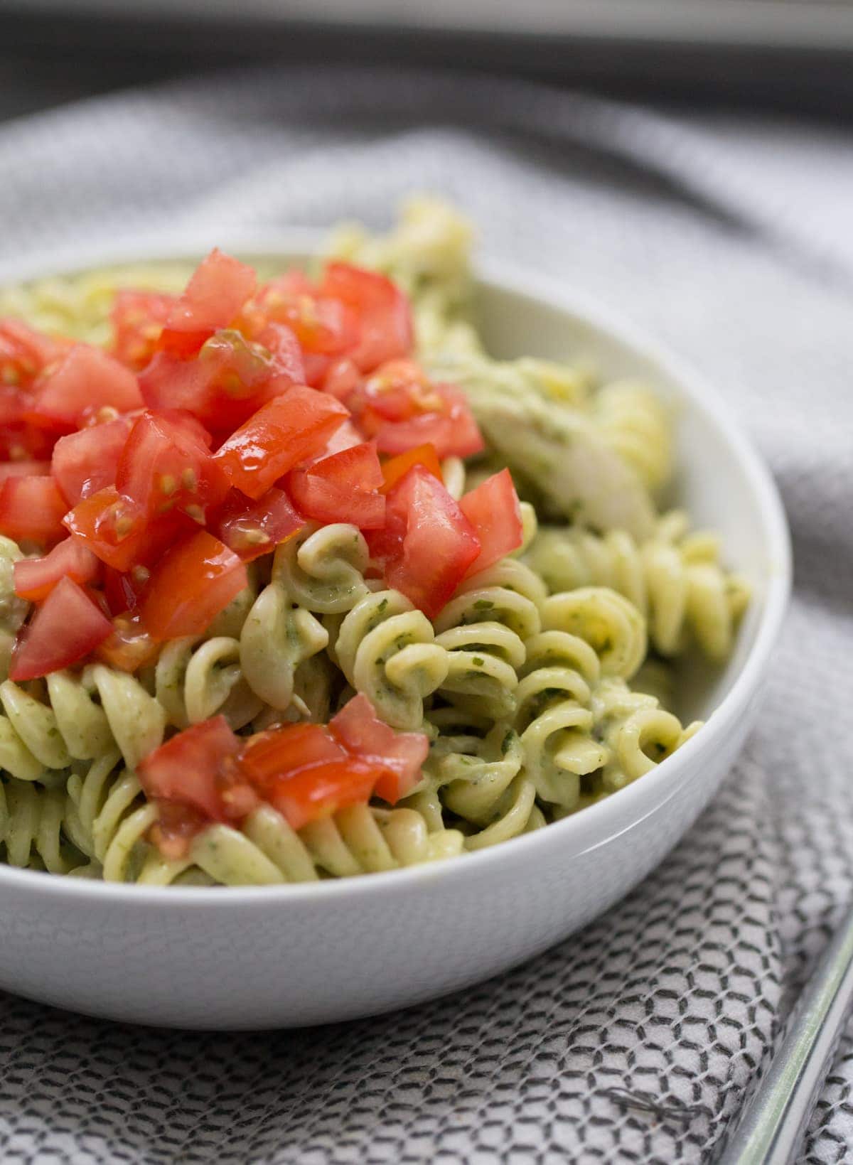 chicken pesto pasta with tomatoes on top