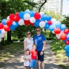 Brennan family under fourth of july balloon arch