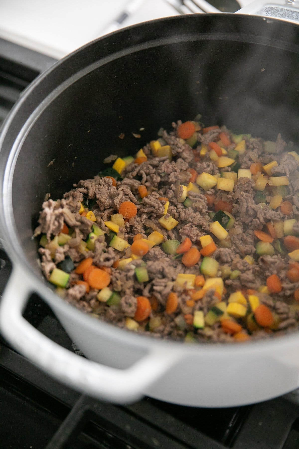 browned beef and vegetables in pot
