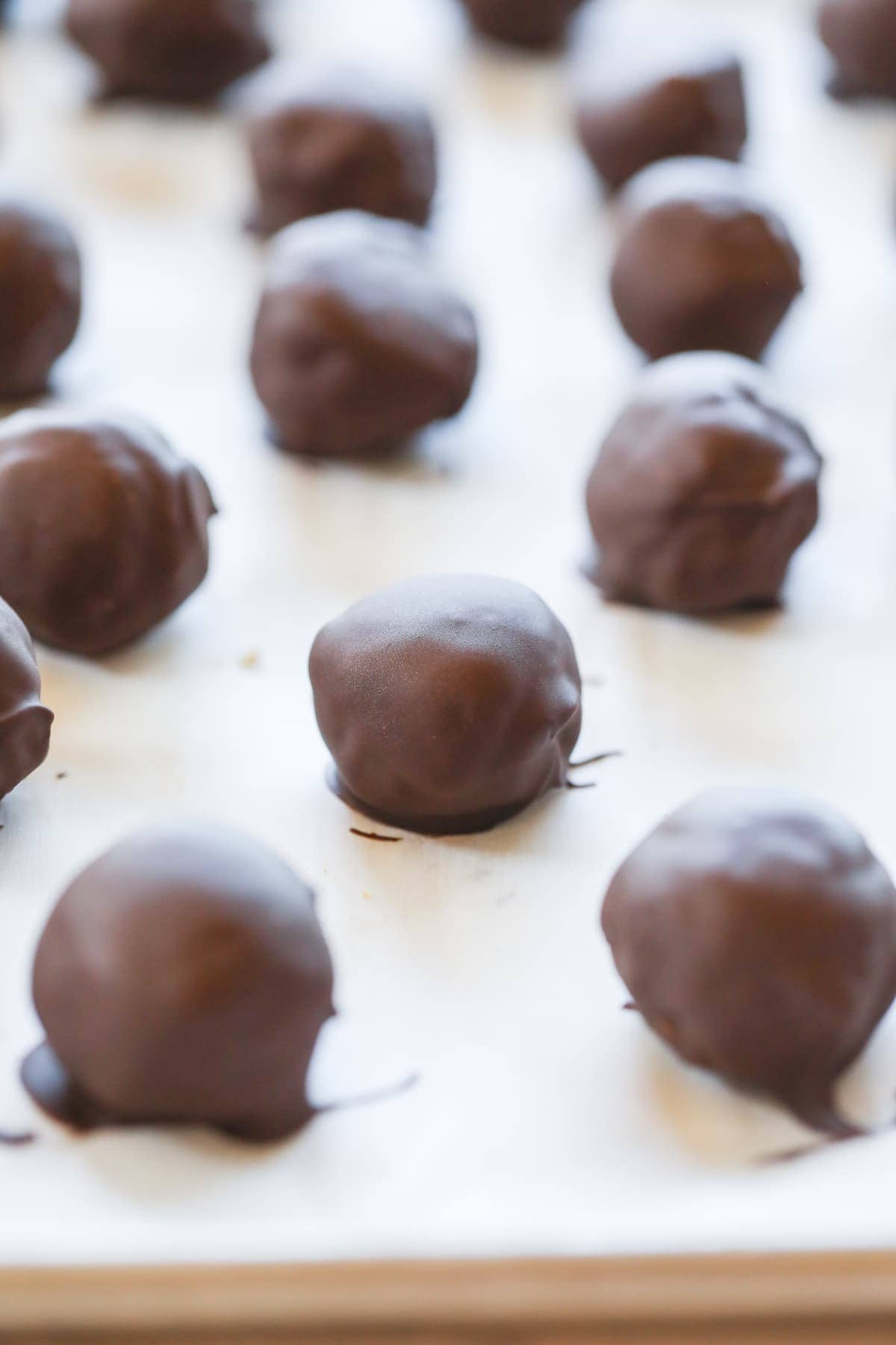 chocolate covered peanut butter balls on parchment paper