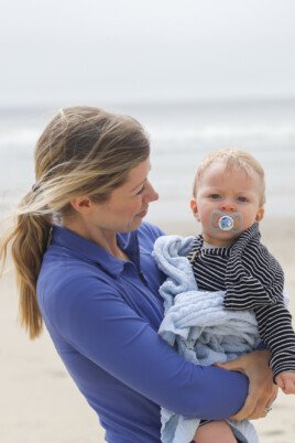 mom holding baby at the beach