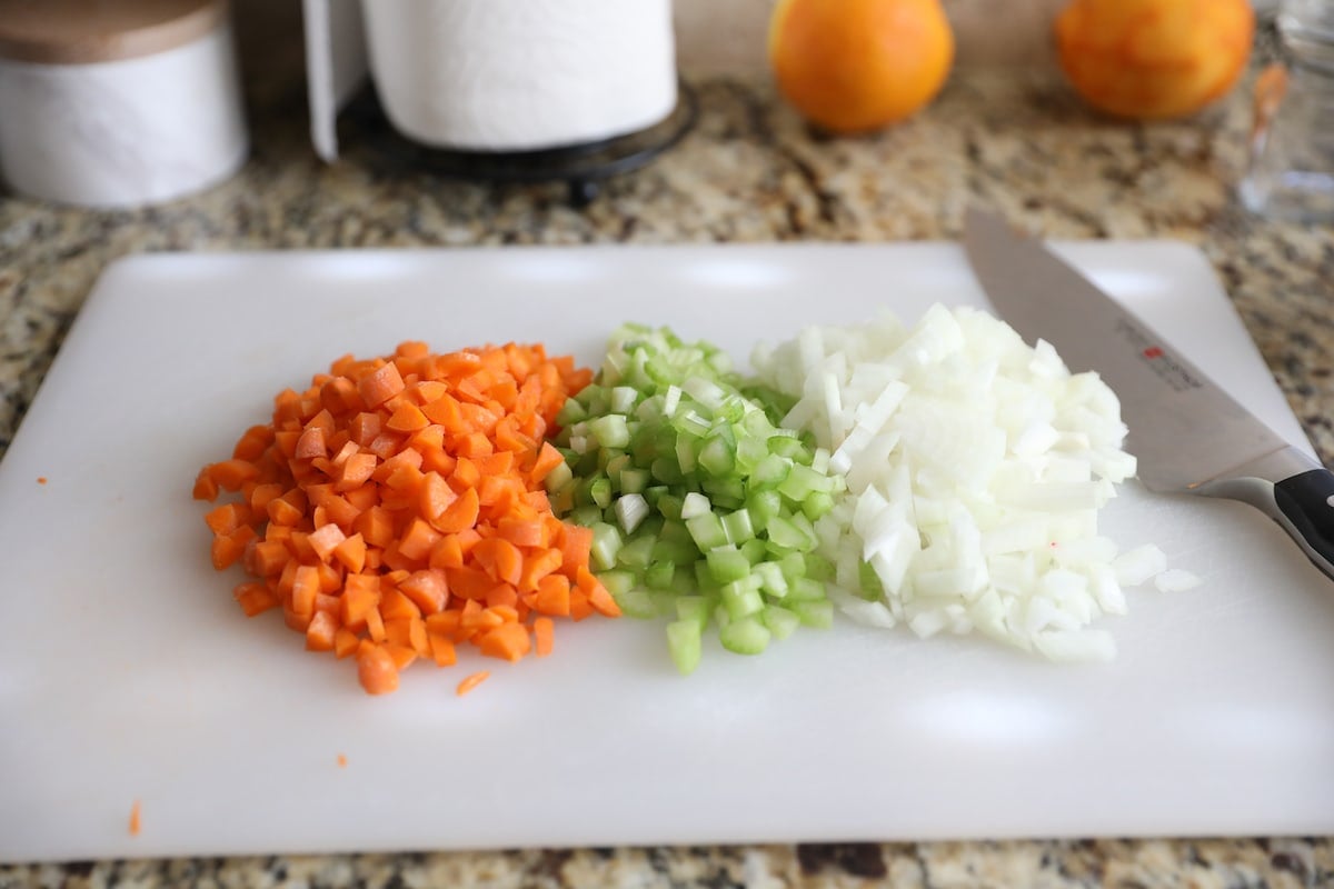 chopped onion, celery and carrot on cutting board