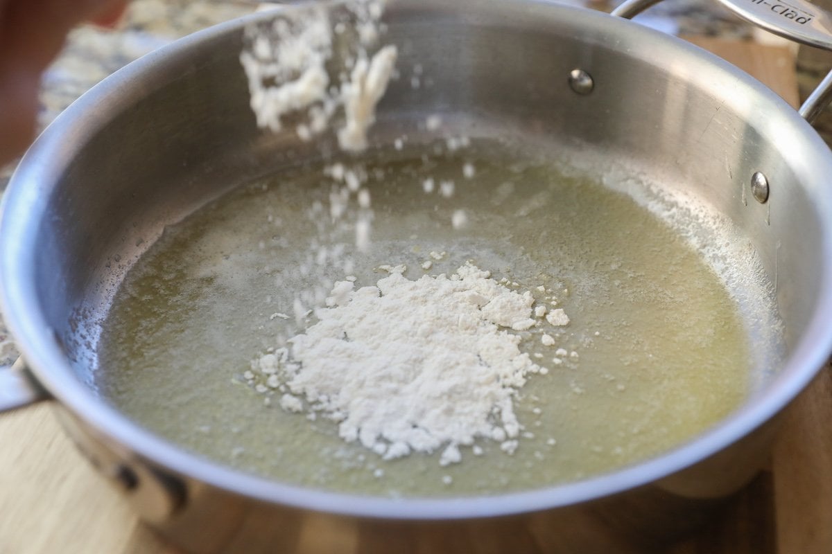 sprinkling flour into a pan with butter