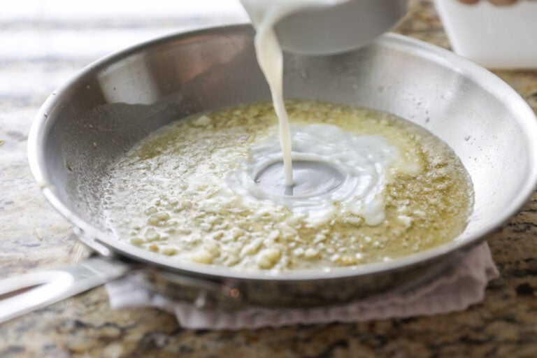 pouring milk into butter and garlic