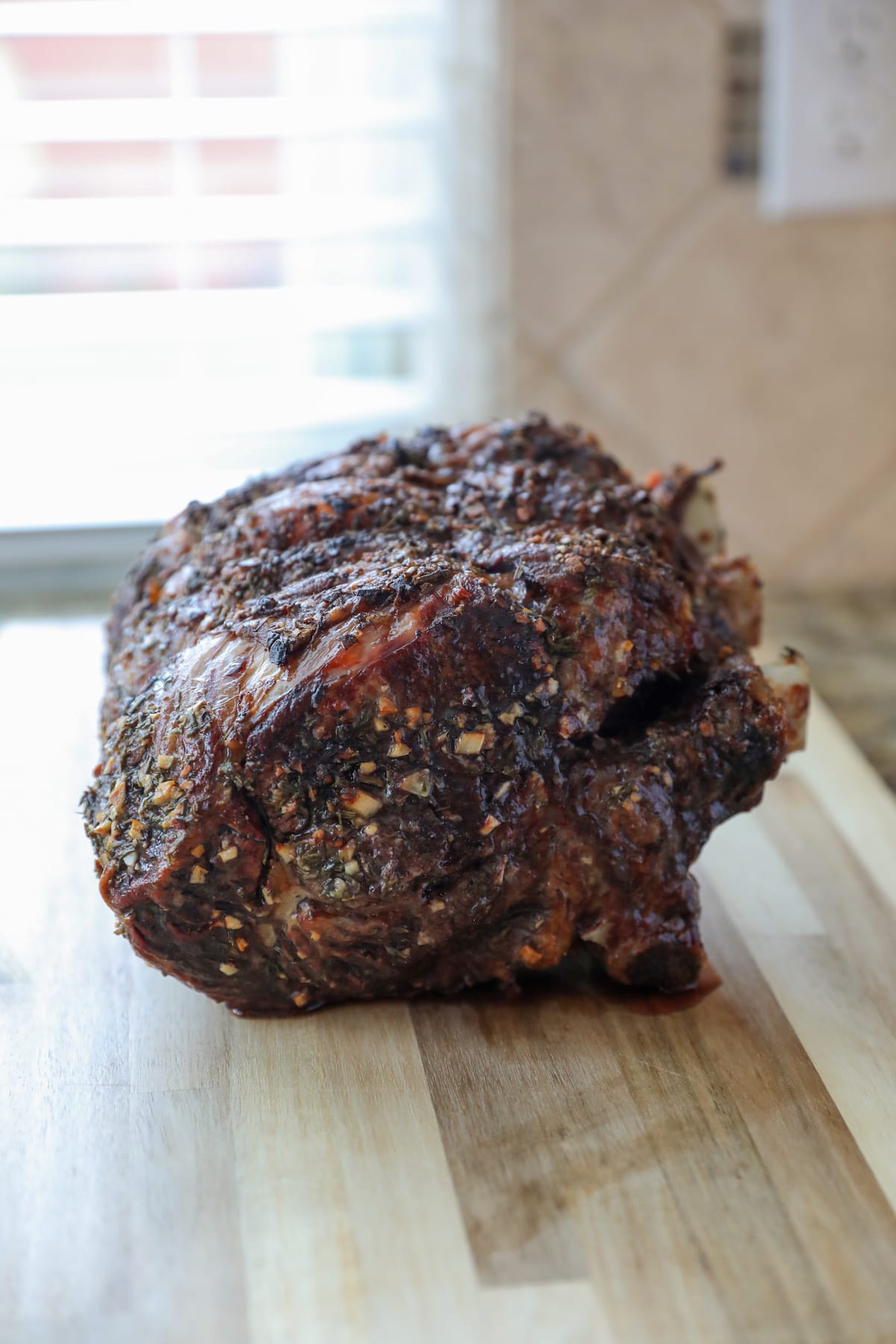 whole roasted prime rib on wooden cutting board