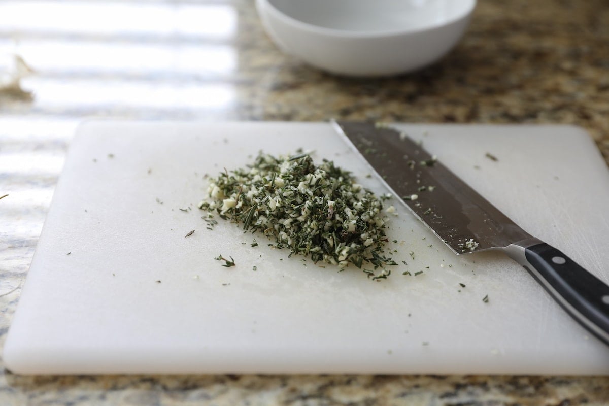 chopped garlic and herbs on cutting board