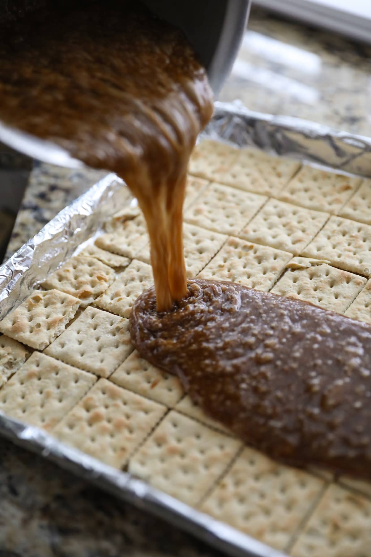 pouring toffee onto saltine crackers