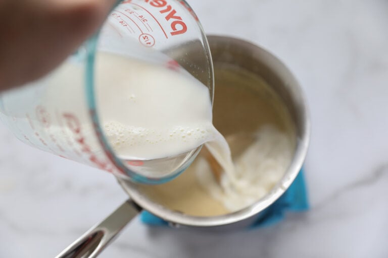 pouring heavy cream into egg nog mixture
