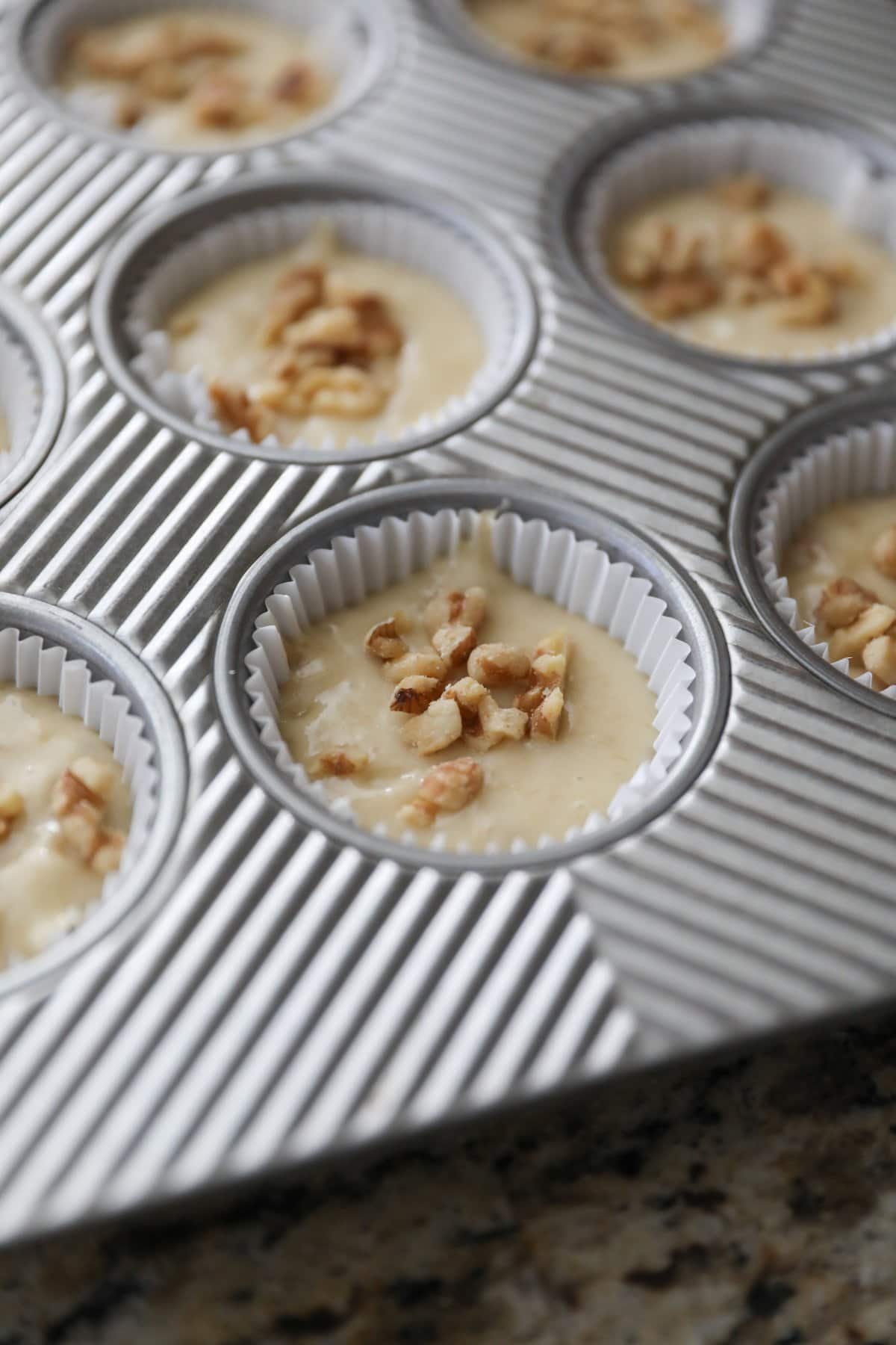 muffin tin filled with batter for banana nut muffins