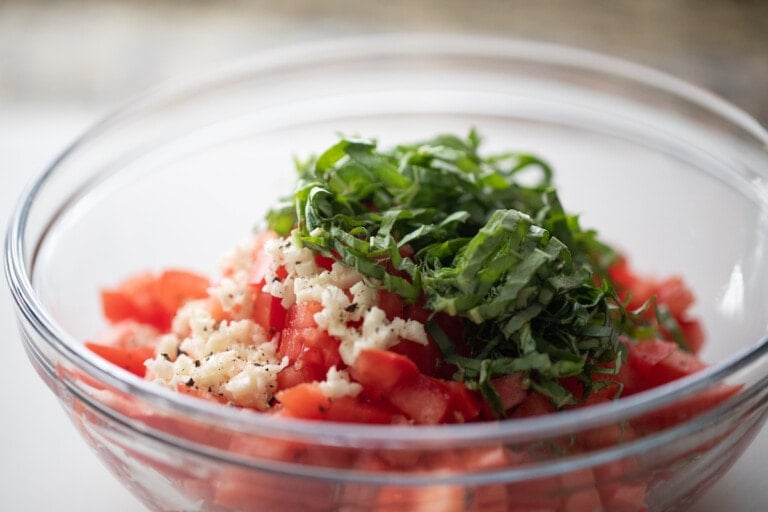 diced tomatoes, garlic and basil in glass bowl