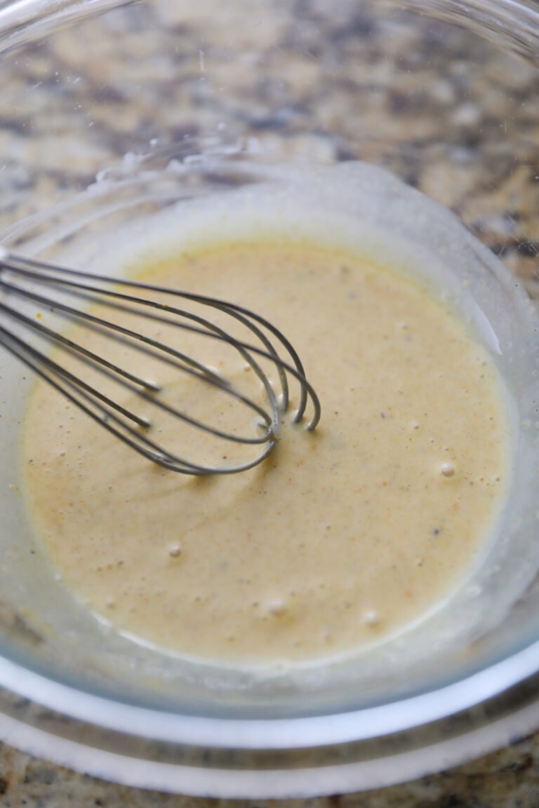sauce in a glass bowl with a whisk