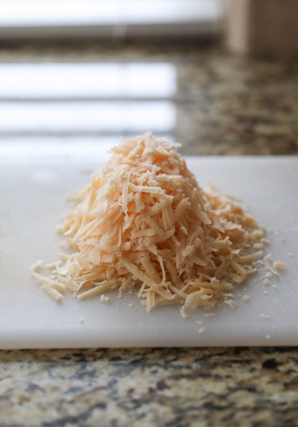 grated parmesan cheese on cutting board