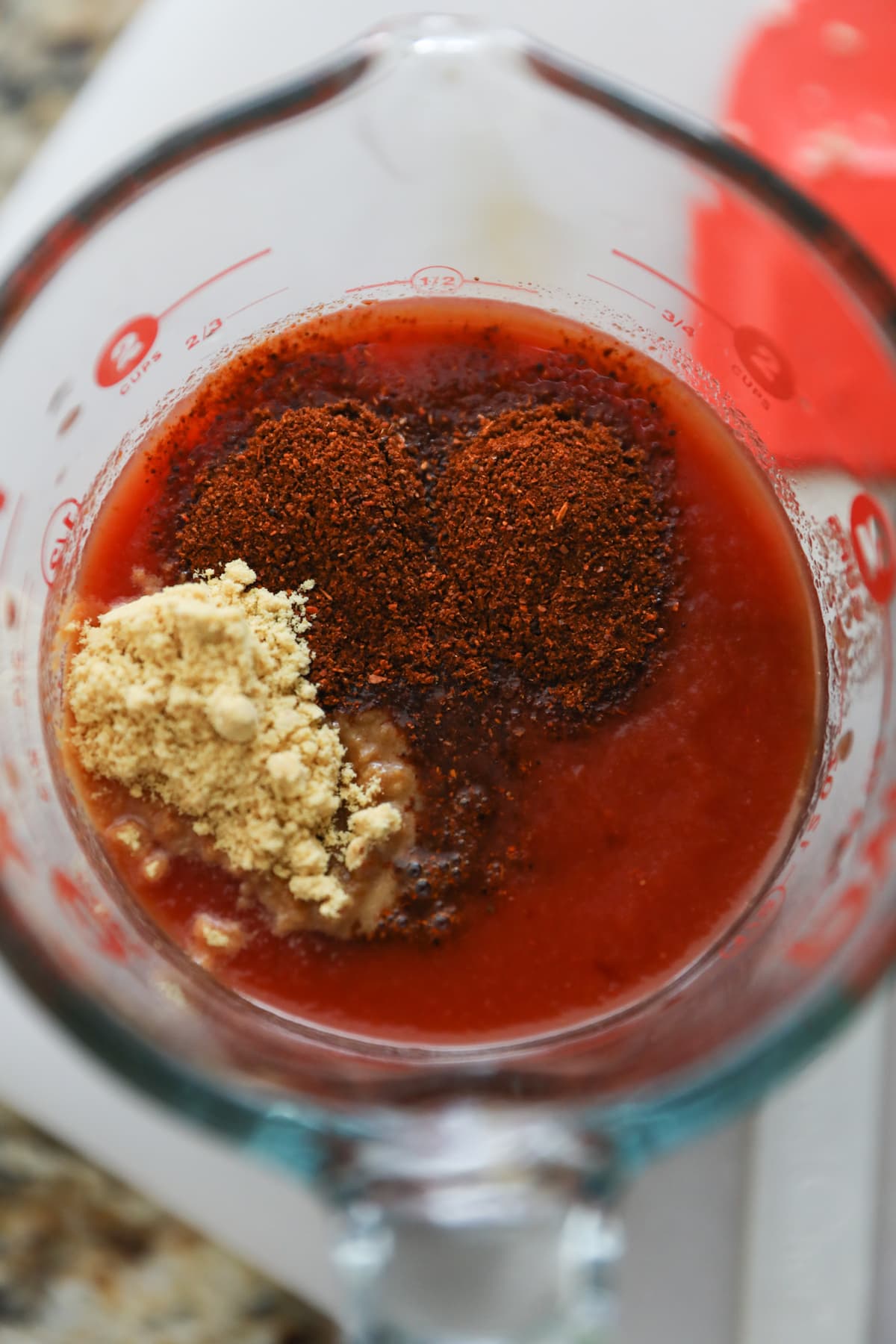 ketchup, water, chili powder and dried mustard in liquid measuring cup