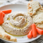 white bean hummus on plate with pita and carrots