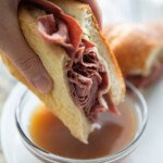 dipping french dip sandwich in au jus