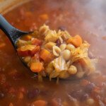 ladling minestrone soup out of pot