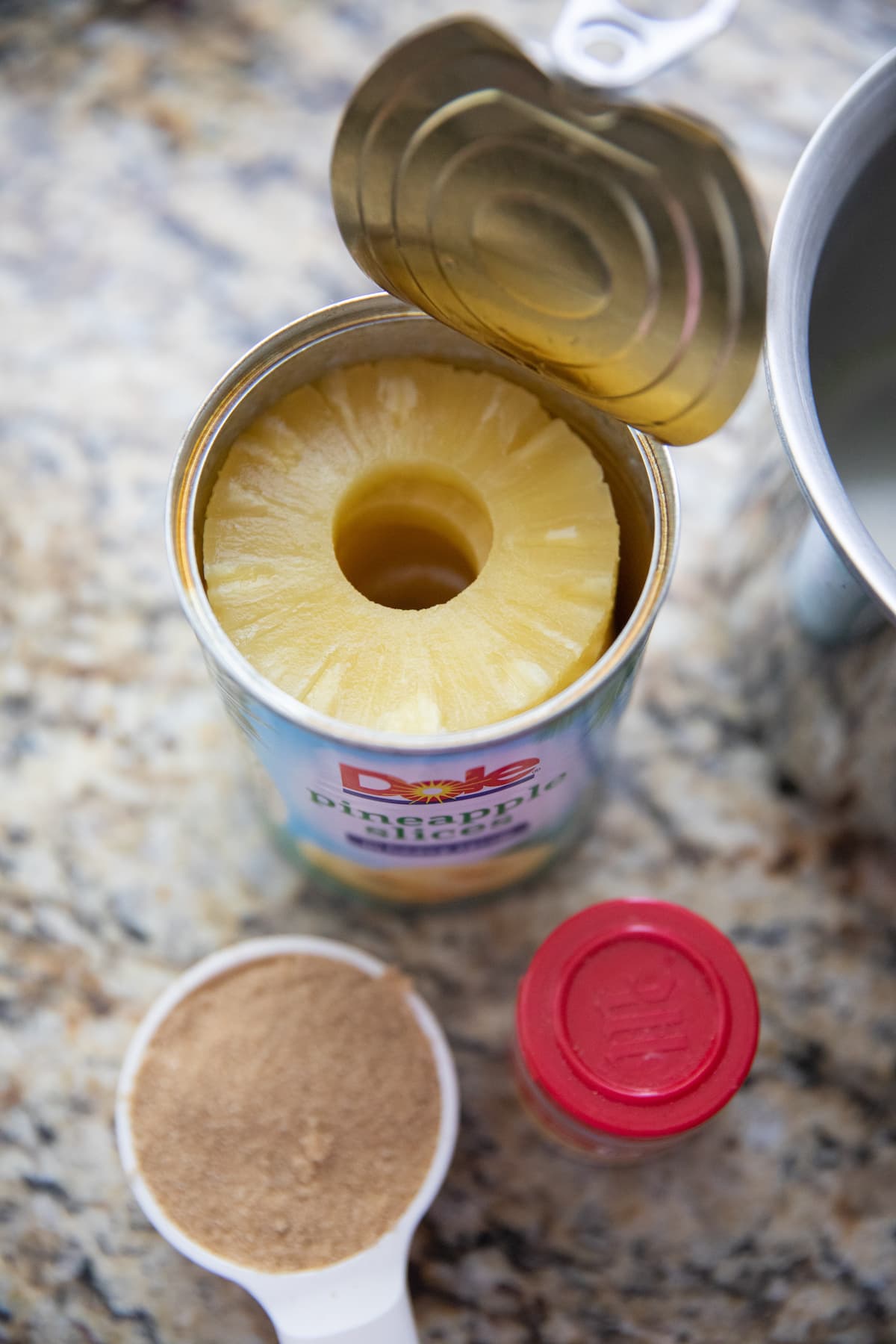 can of pineapple, brown sugar and cloves on counter