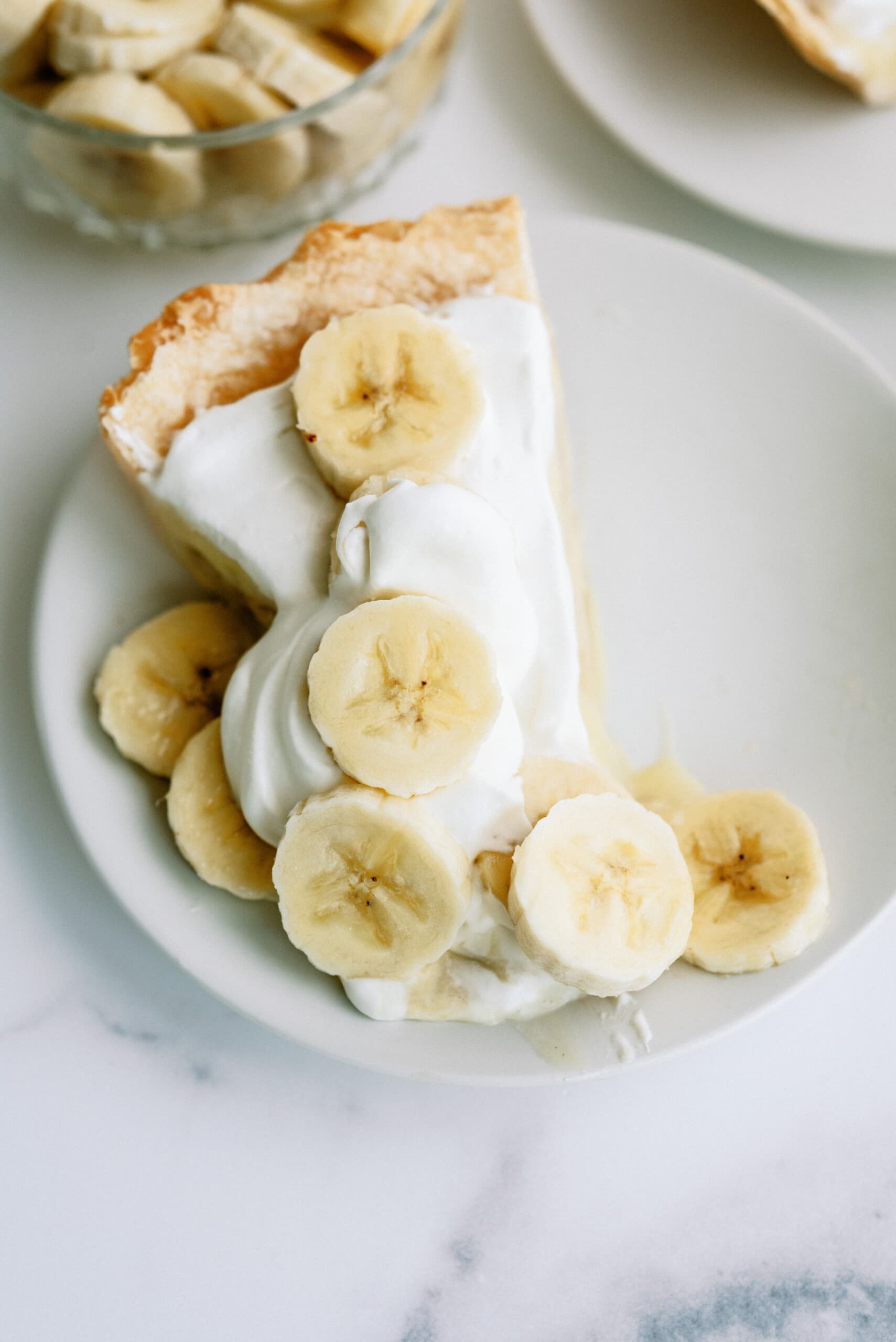 a slice of banana cream pie on a white plate