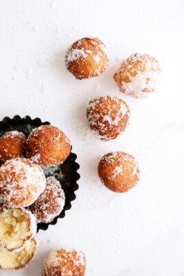 top down view of donut holes in a bowl and on the counter