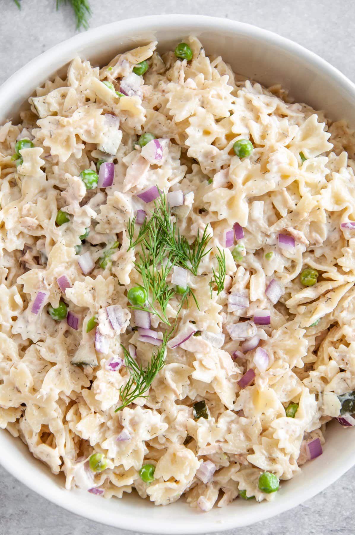 adding dill and red onions to tuna pasta salad