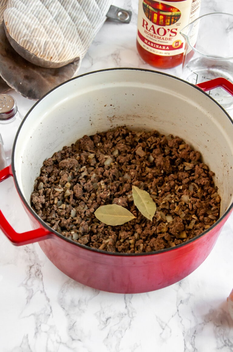 ground beef and other ingredients in a red cooking pot