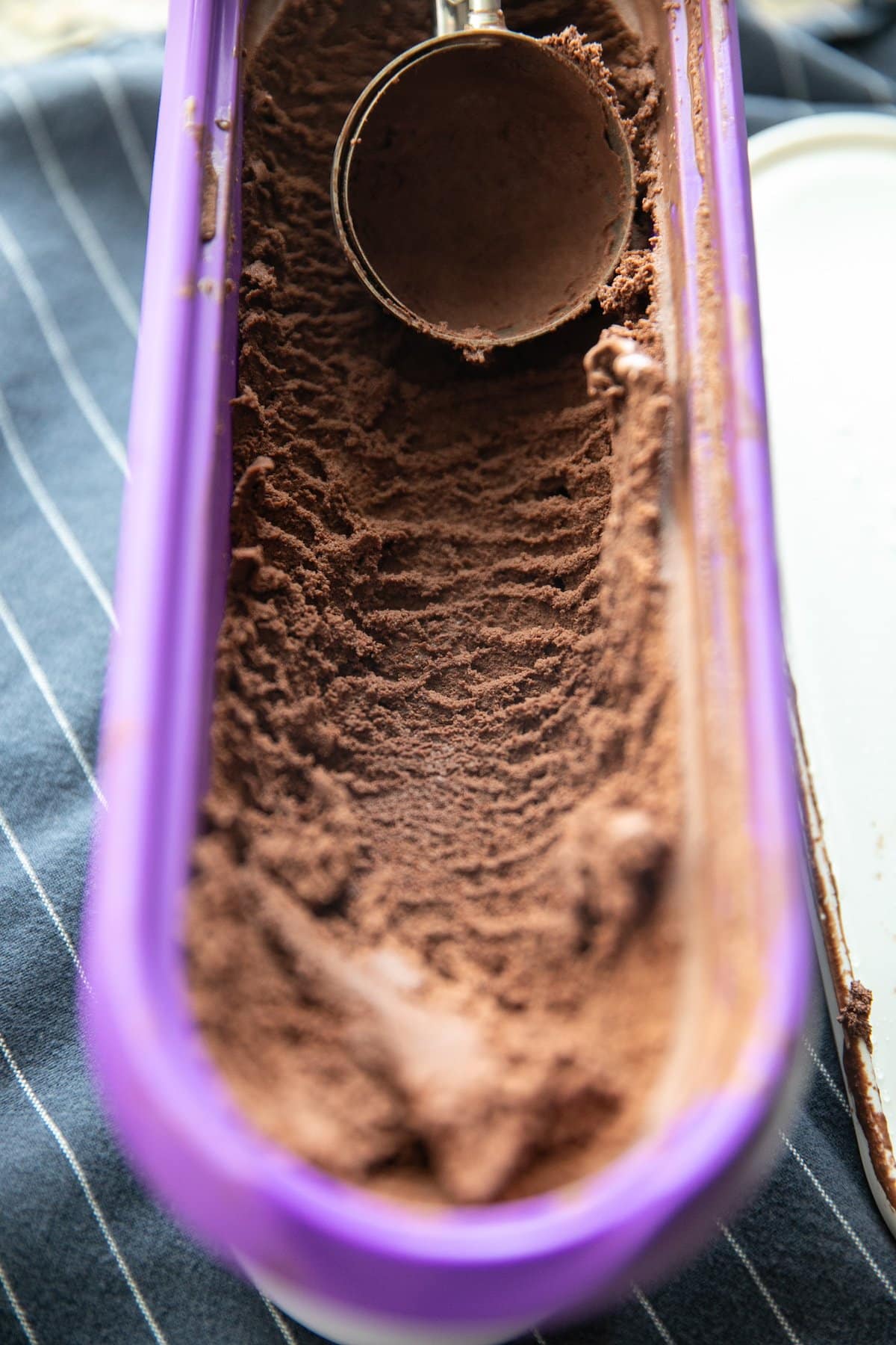 Mengambil es krim cokelat dari wadah ungu