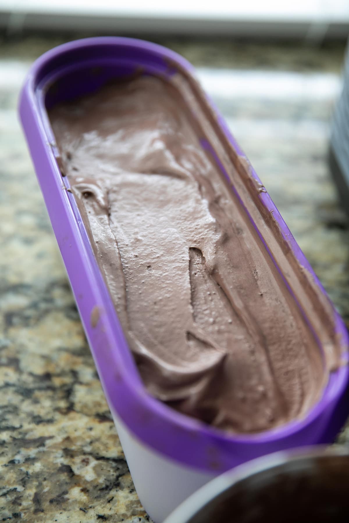 chocolate ice cream in purple plastic container