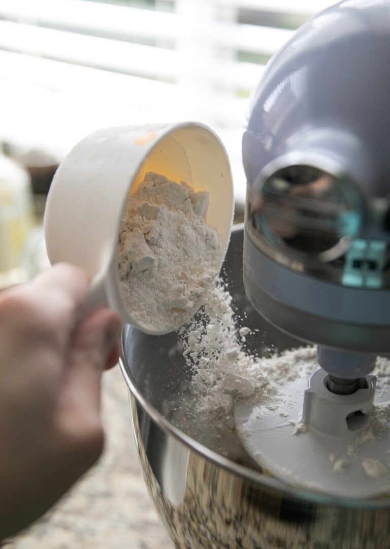 adding bread flour to the stand mixer bowl