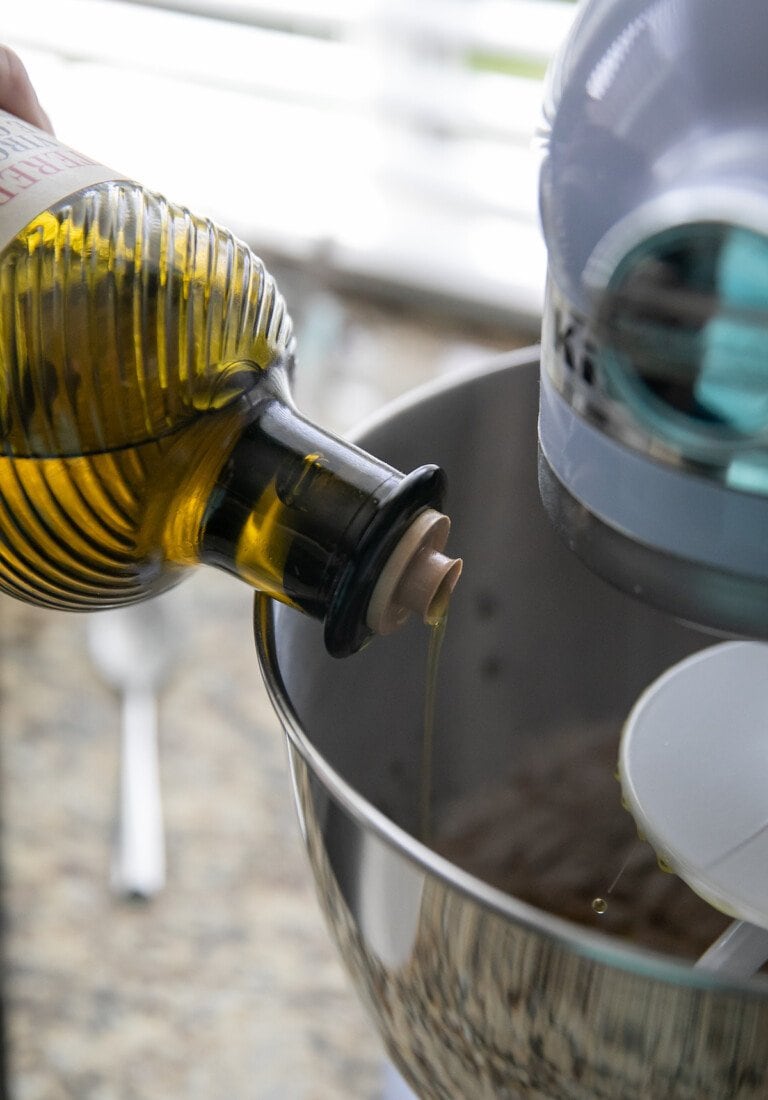 adding olive oil to stand mixer bowl