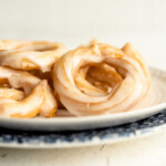 side view of french crullers on a plate