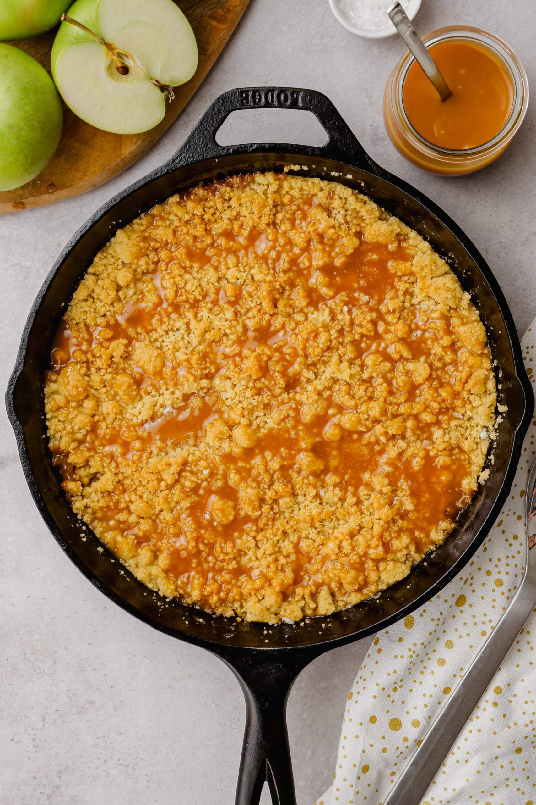 baked salted caramel apple crumble in a cast iron skillet