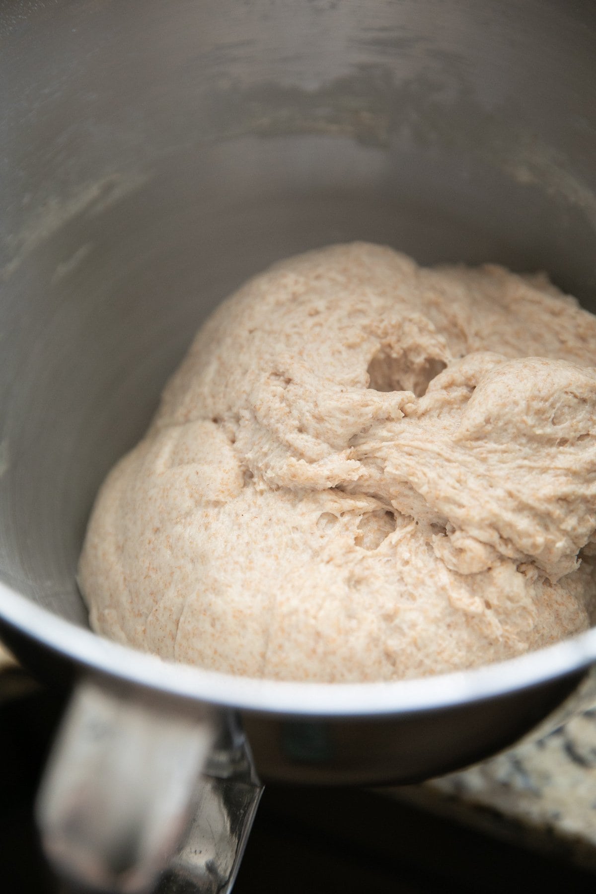 whole wheat bread dough in a metal mixing bowl