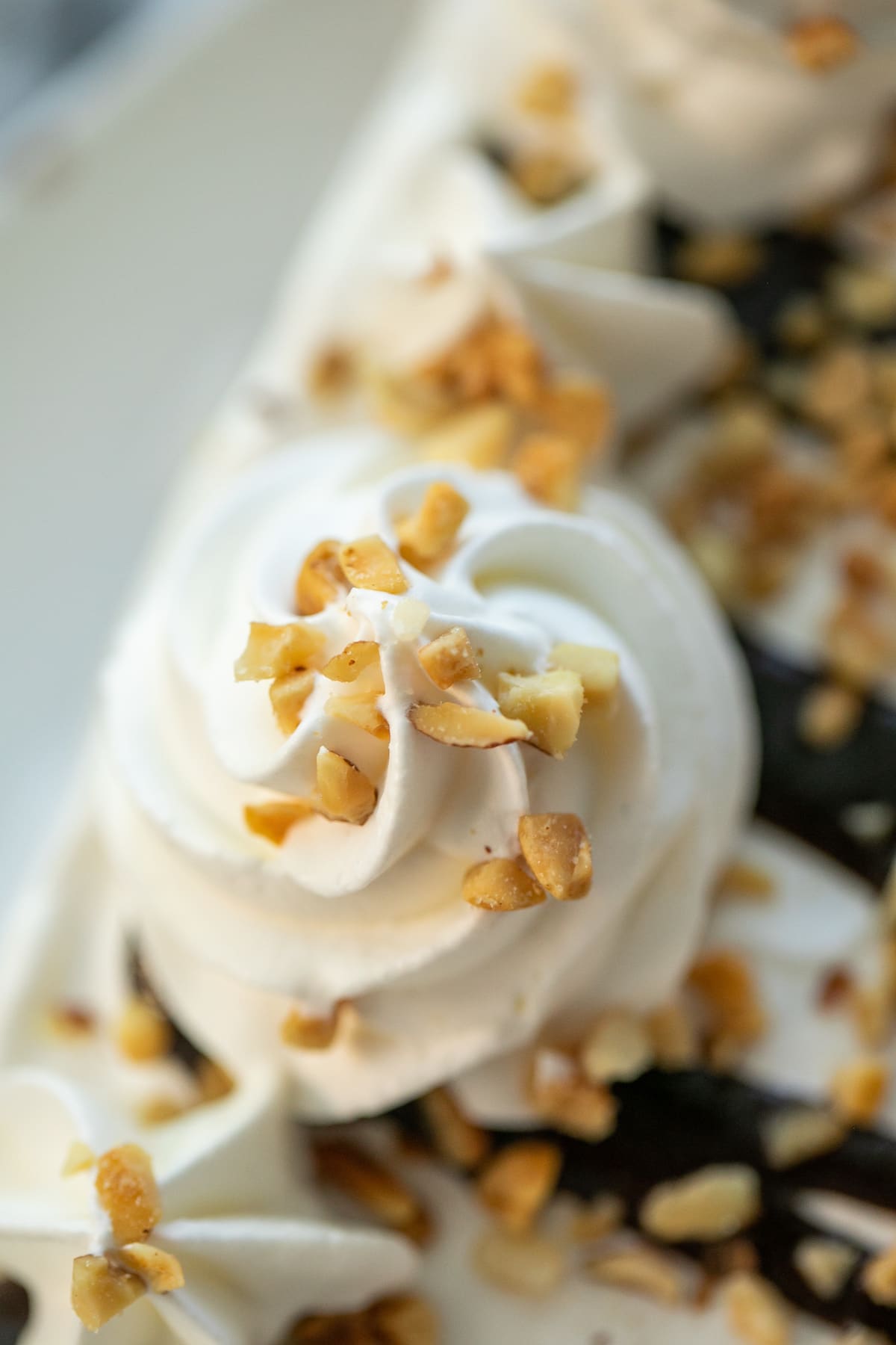 close up shot of cream rosette on ice cream cake
