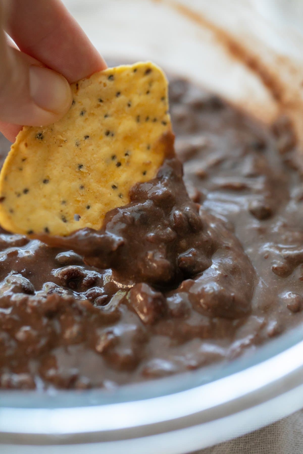 dipping chip in refried beans