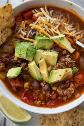 taco soup with avocado and cheese in bowl