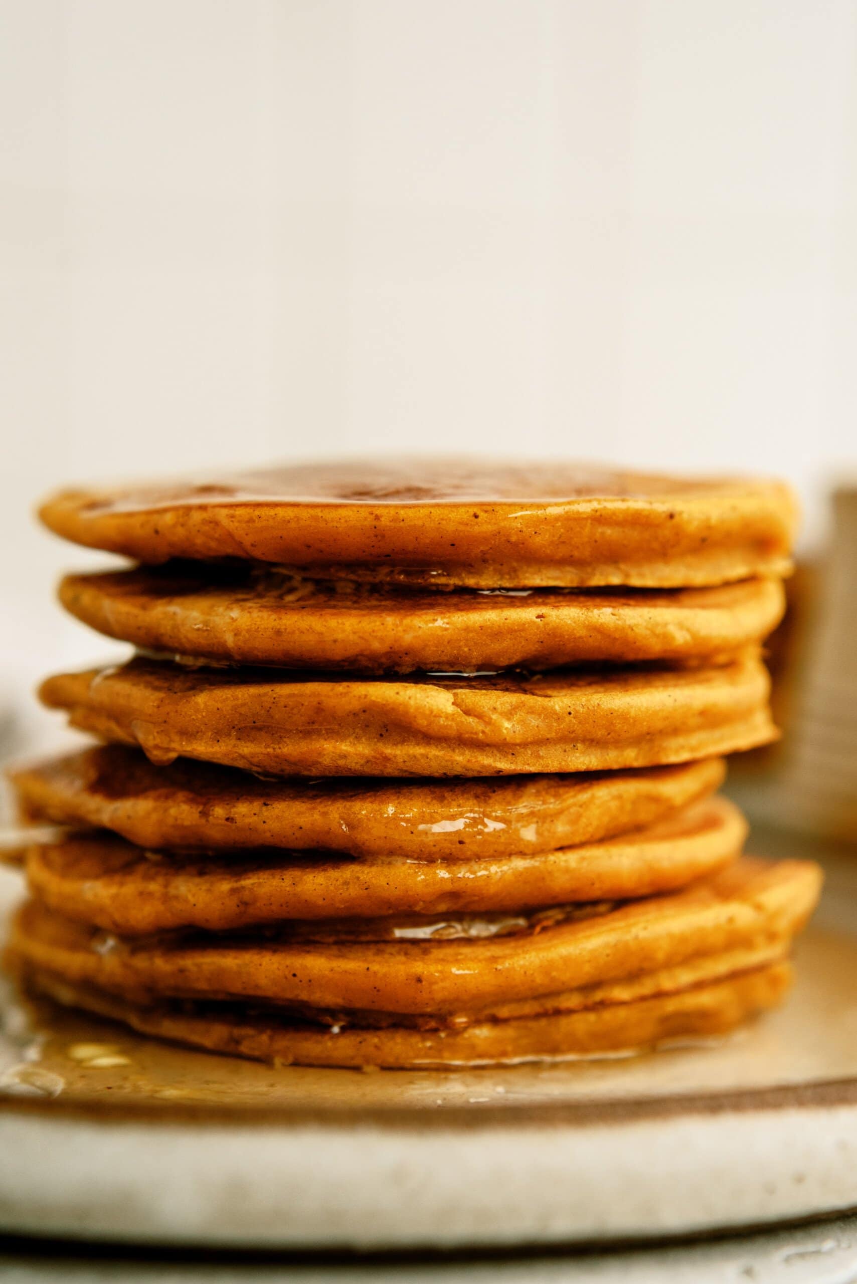 side view of a stack of pumpkin pancakes on a plate