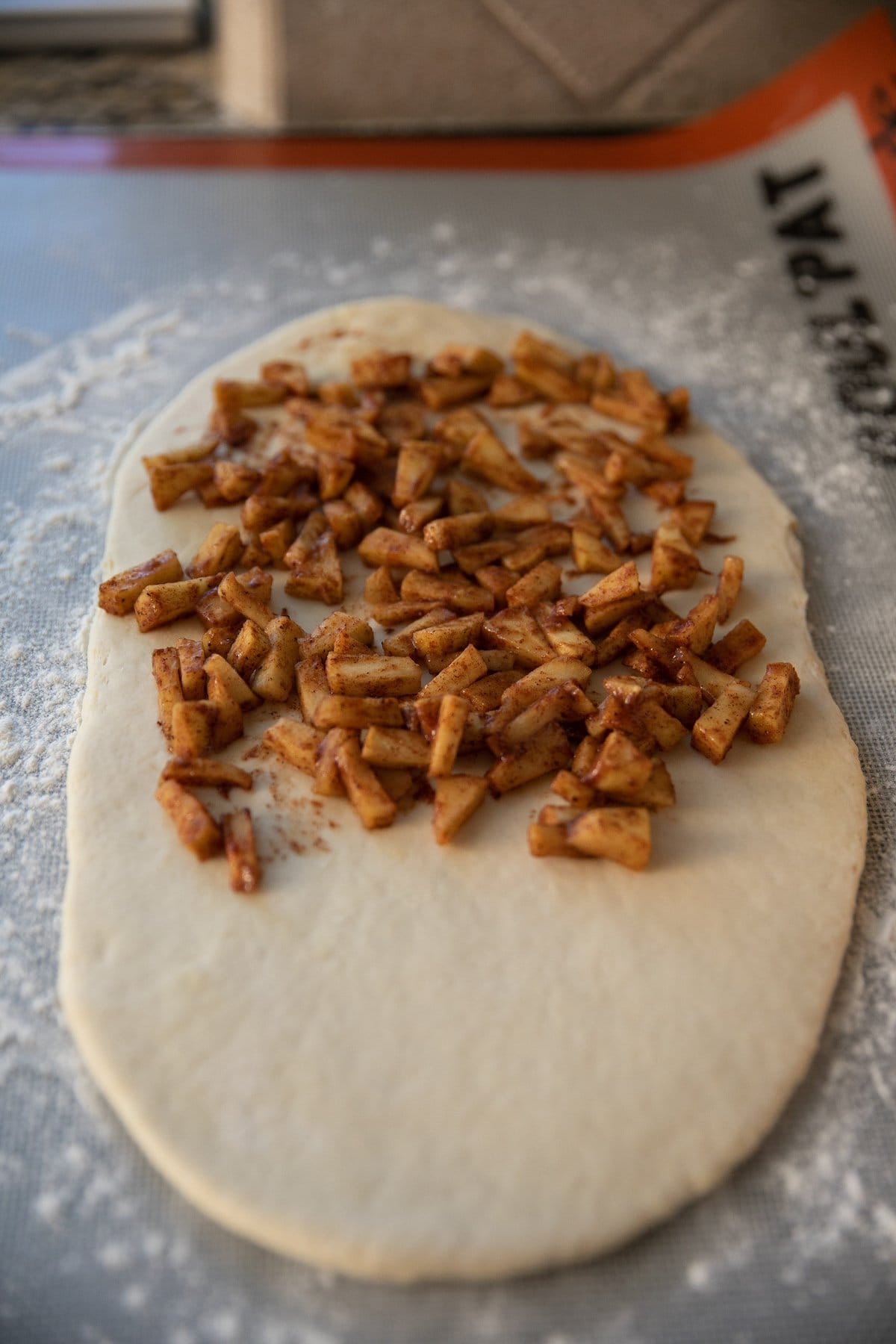 cooked diced apples on half of the rolled out dough