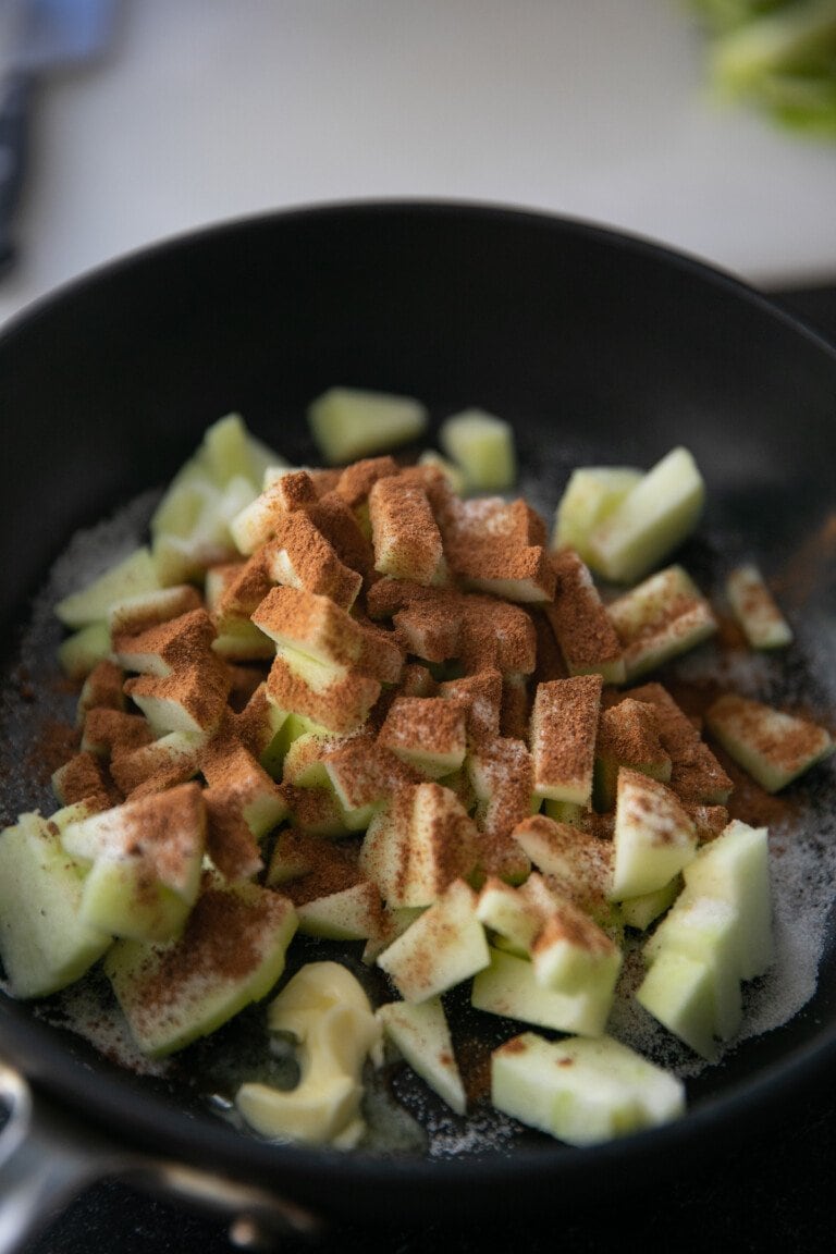 diced apples in a pan with cinnamon