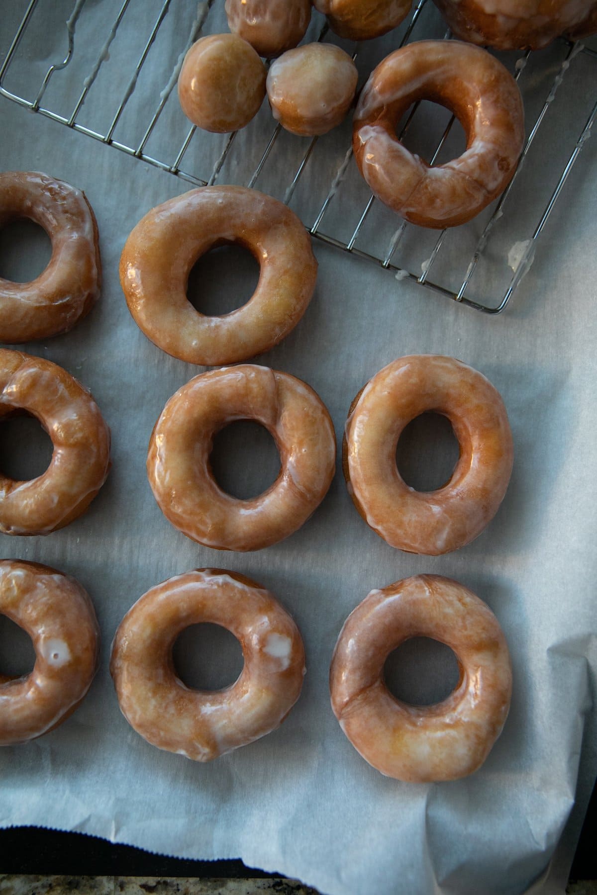 top down view of glazed donuts on parchment paper