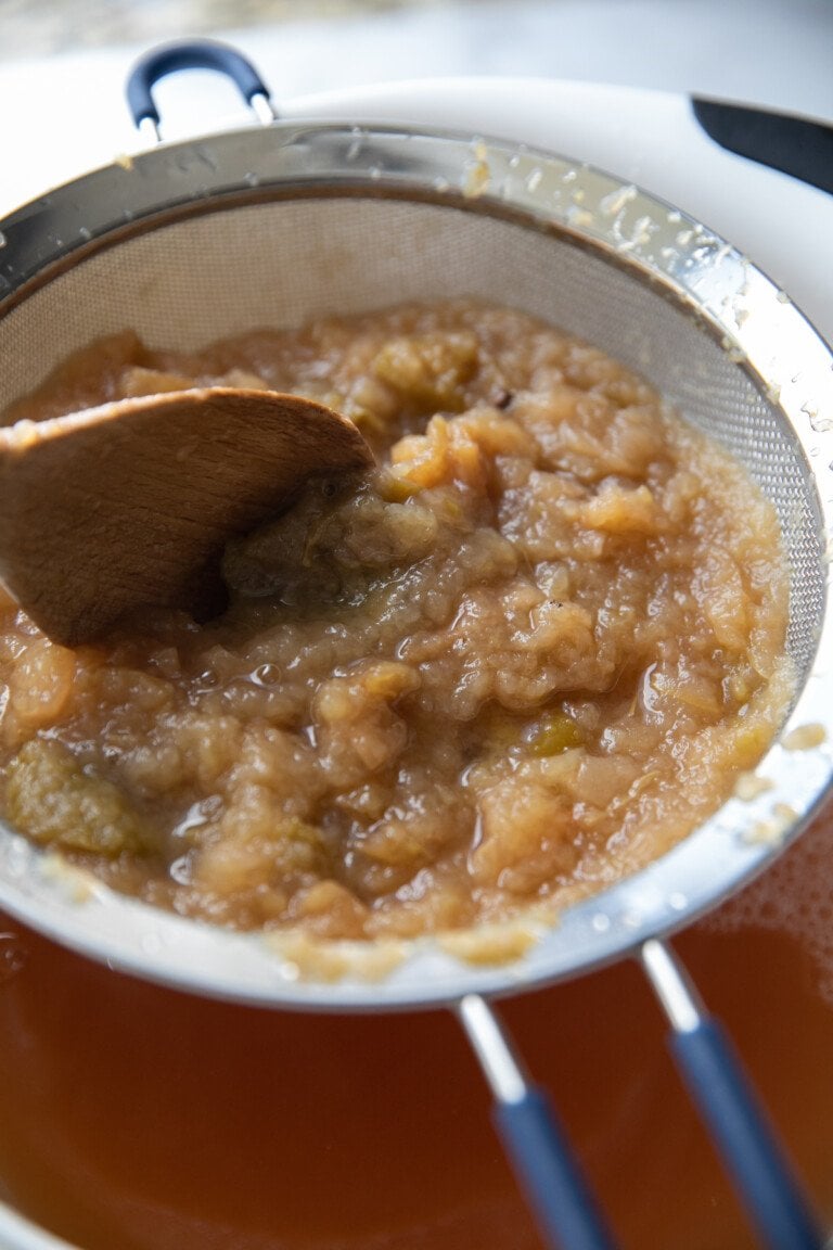 straining mashed mixture into a bowl