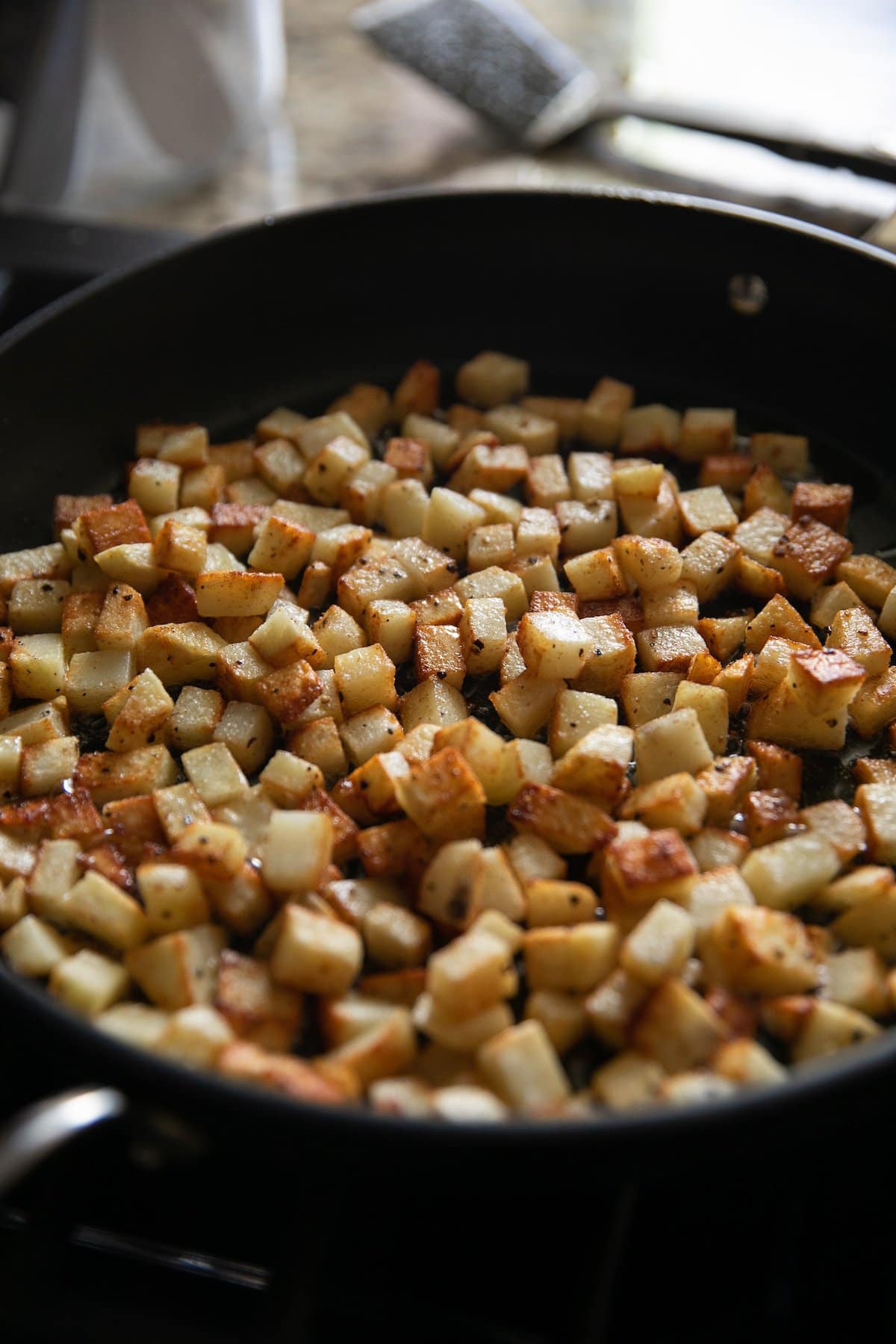 diced potatoes being fried in a pan