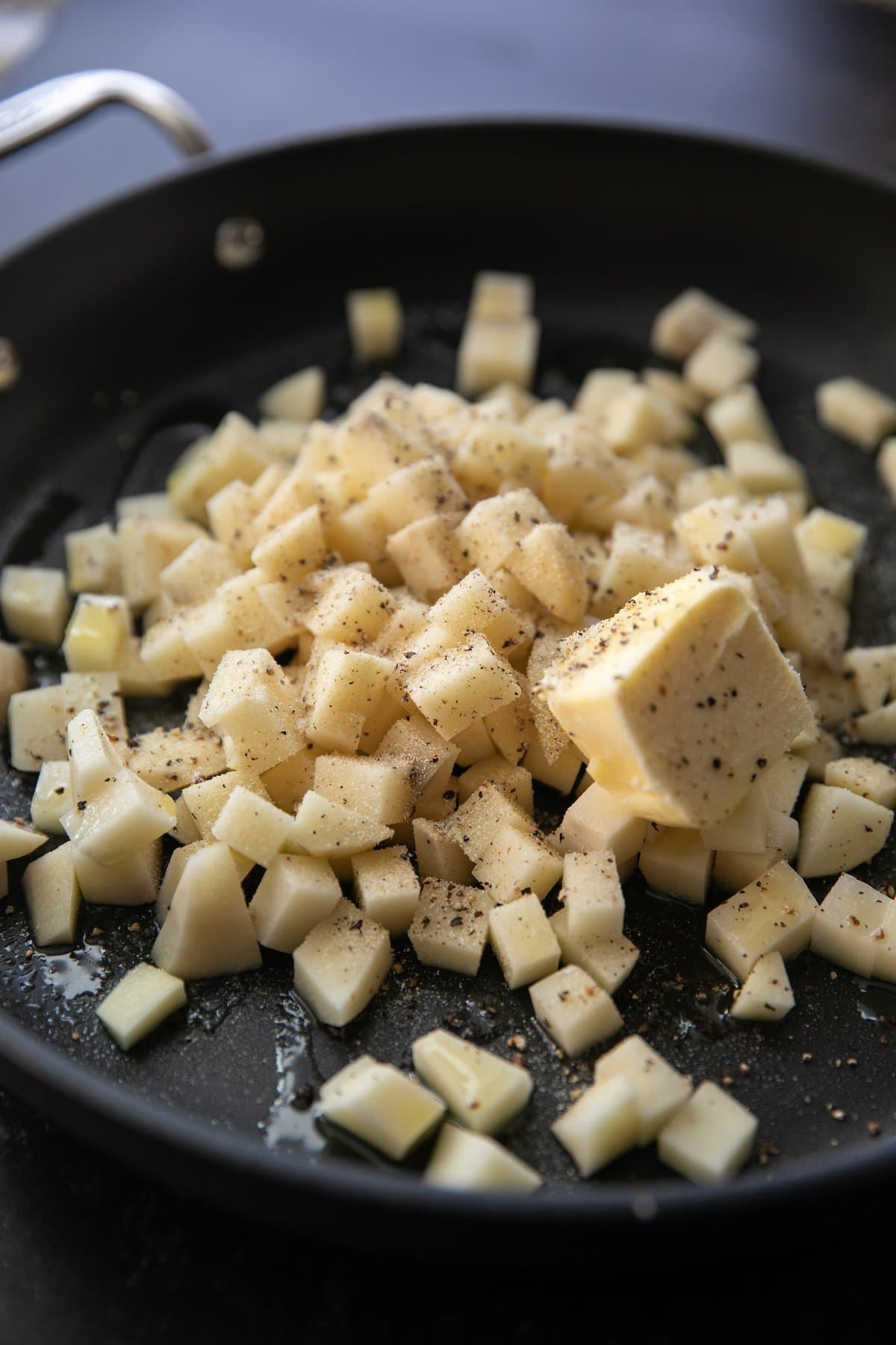 diced potatoes in a pan with butter and seasonings