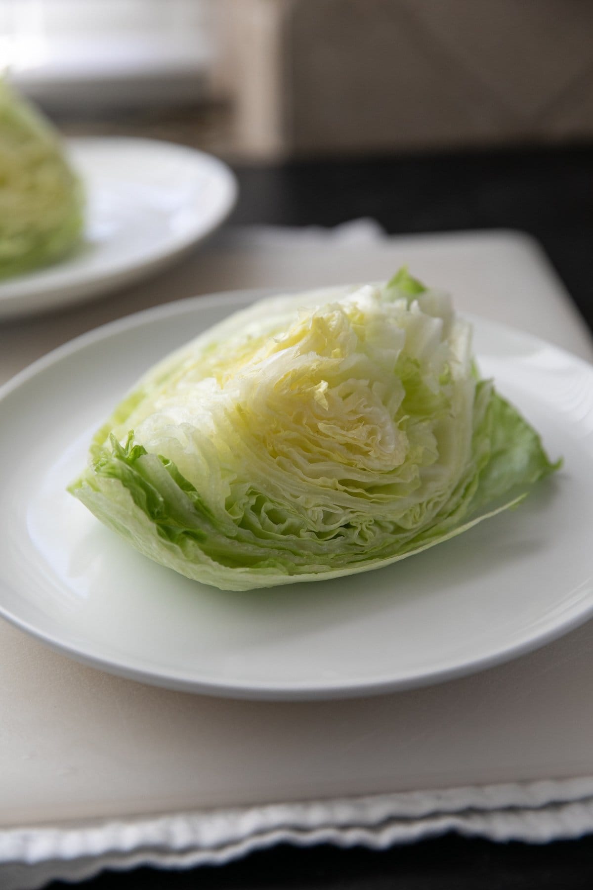 a wedge of iceberg lettuce on a white plate
