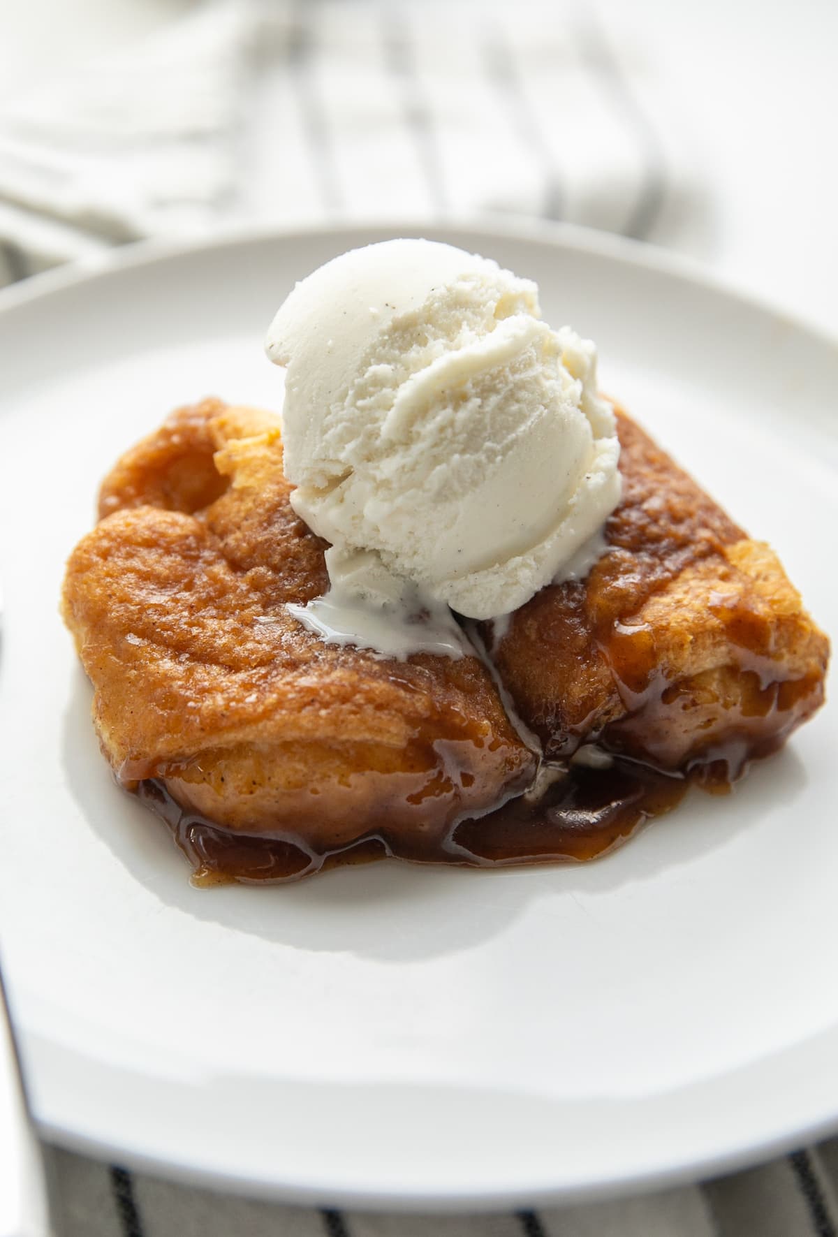 two apple dumplings on plate with ice cream