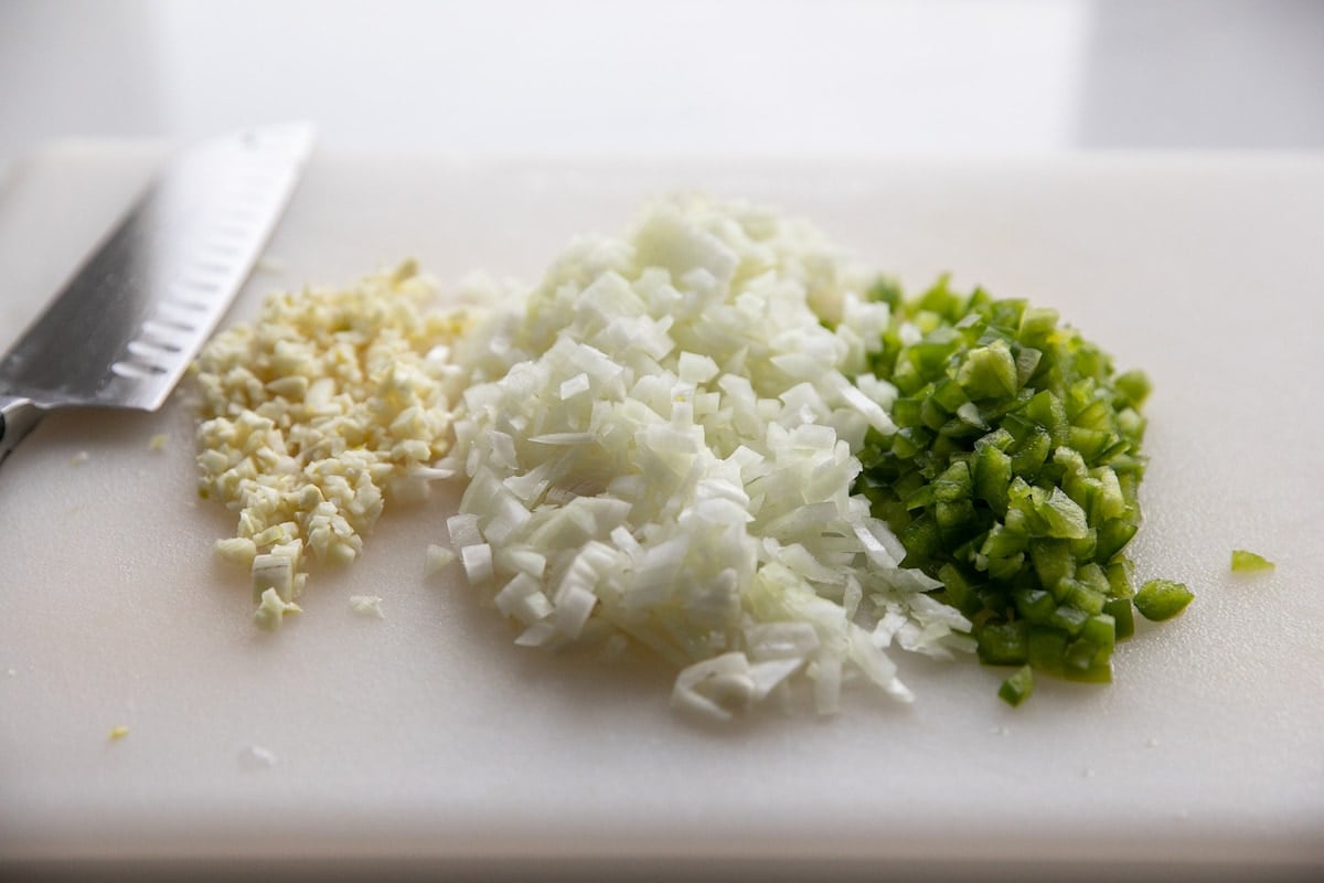 chopped garlic, onion and peppers on cutting board
